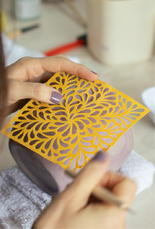 Decoraci&oacute;n de una pieza de cer&aacute;mica con est&eacute;ncil calado amarillo de dise&ntilde;o org&aacute;nico